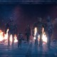 The Guardians of the Galaxy walking toward the camera with flames in the background