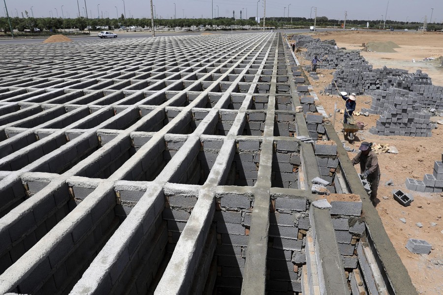 Hundreds of empty graves stand in rows, made up of cinder blocks and mortar.