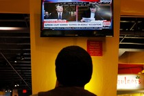 A person watches a television broadcast of the Kavanaugh hearing.