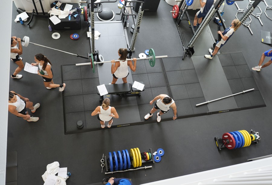 Athletes are seen working out with free weights.