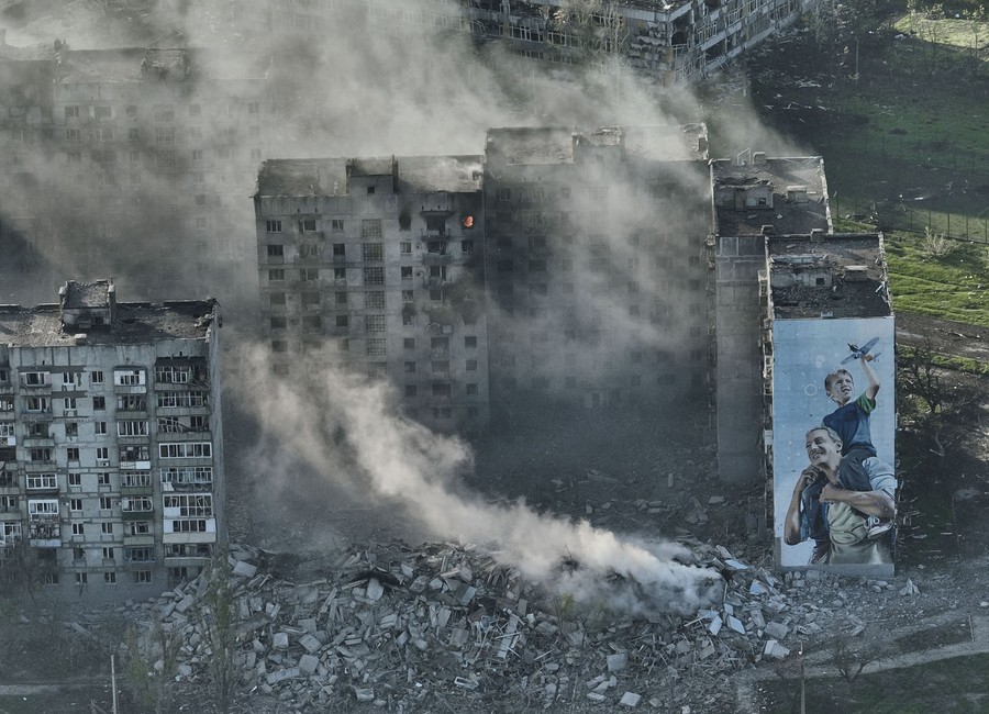 Smoke rises from a war-damaged building in Ukraine.