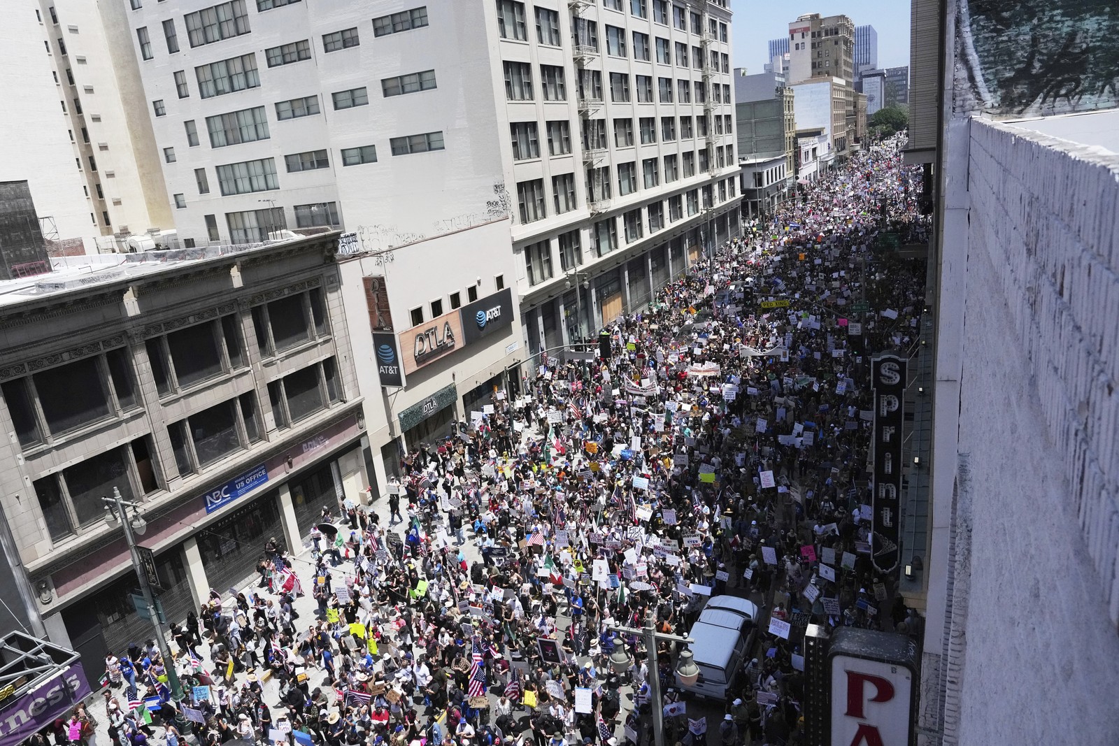 A large crowd of protesters fill a city street during a march.