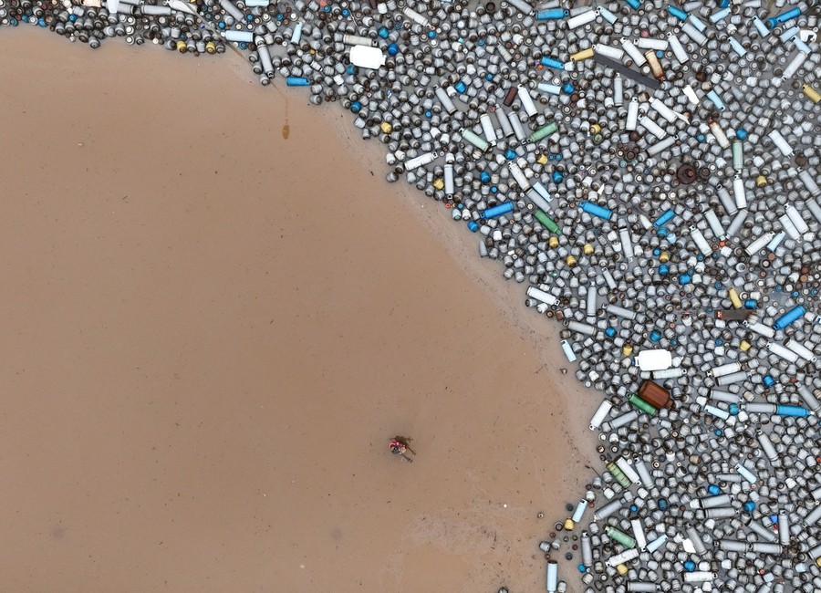 An aerial view of hundreds of gas cylinders scattered by floodwater