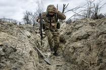 A photo of a Ukrainian soldier running through a trench