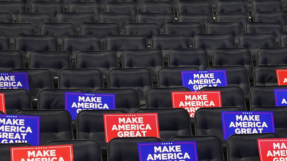 Empty chairs in a venue with “Make America Great Again” signs on them
