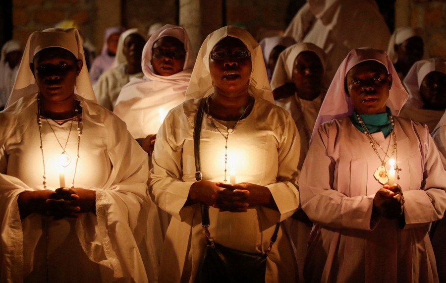 Worshippers hold candles during a New Year's prayer in a church.