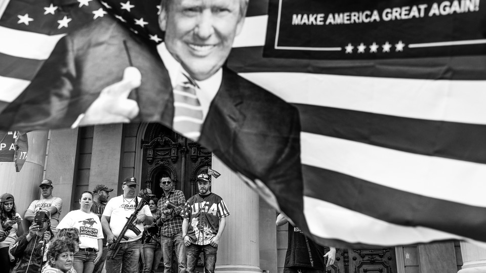 Armed protesters with a flag of Donald Trump