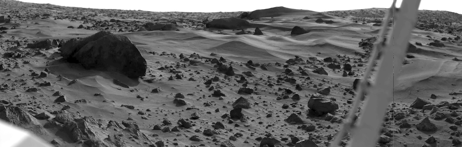 A black-and-white image of the sandy and rocky surface of Mars