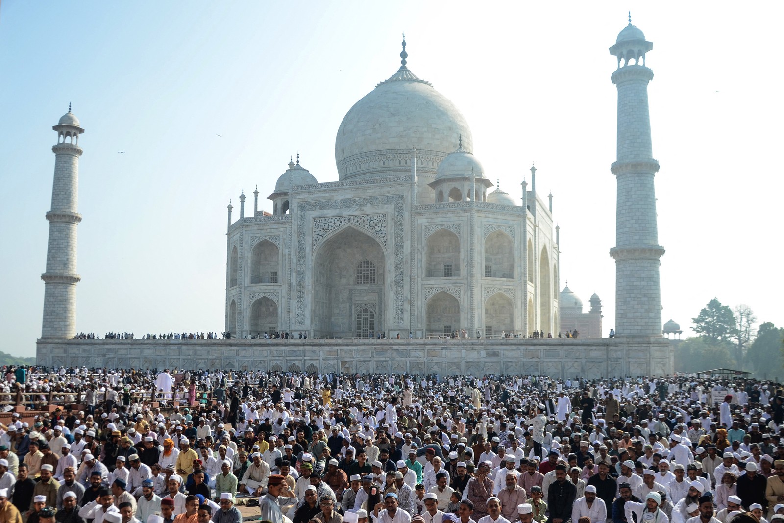 A large group of Muslims offer prayers outside the Taj Mahal.