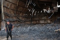 a man with a gun stands among rubble