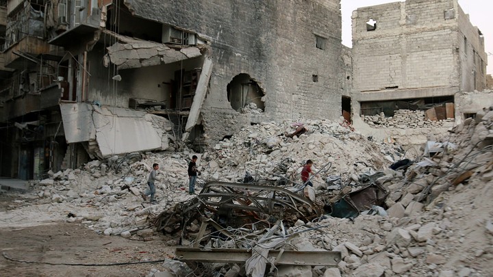 Boys climb over rubble