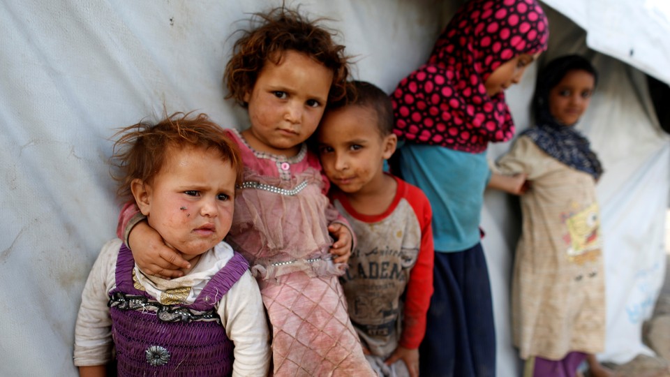 Children stand next to a tent at a camp for people displaced by the war near Sanaa, Yemen.