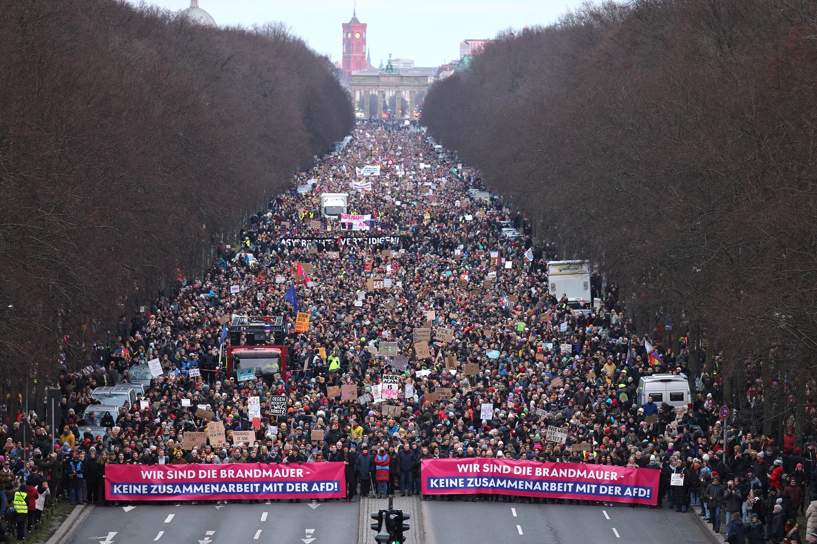 A large crowd of protesters march in Berlin, carrying banners that, translated from German, read, “We are the firewall. No cooperation with the AfD.”