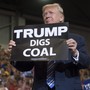 President Donald Trump holds up a "Trump digs coal" sign as he arrives to speak during a Make America Great Again rally at Big Sandy Superstore Arena in Huntington, West Virginia, on August 3, 2017.