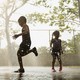 Silhouettes of children running through sprinkles