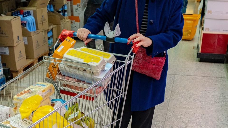 a person pushing a cart in a grocery store