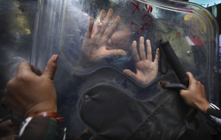 People push on either side of a clear plastic shield.