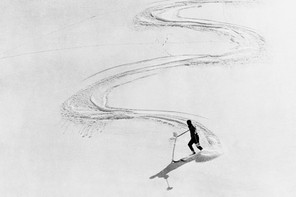 A black and white photograph of a skier coming down a steep alpine with a zig zag-pattern in the snow behind them