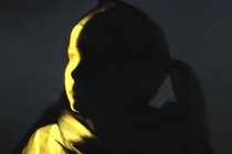 A drawing of a girl's face barely illuminated