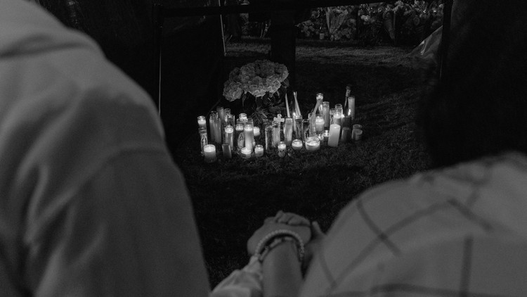 Adzel Marmita holds his daughter's hand at a vigil four days after a gunman shot and killed multiple people at the Dallas-area Allen Premium Outlets mall in Allen, Texas, on May 10, 2023.