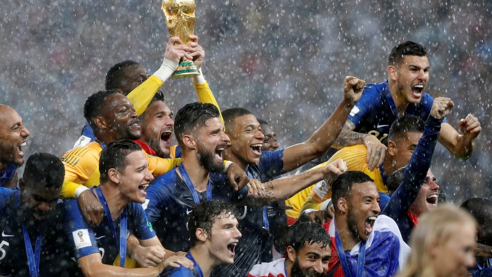 Members of the French national team hold up their World Cup trophy victoriously