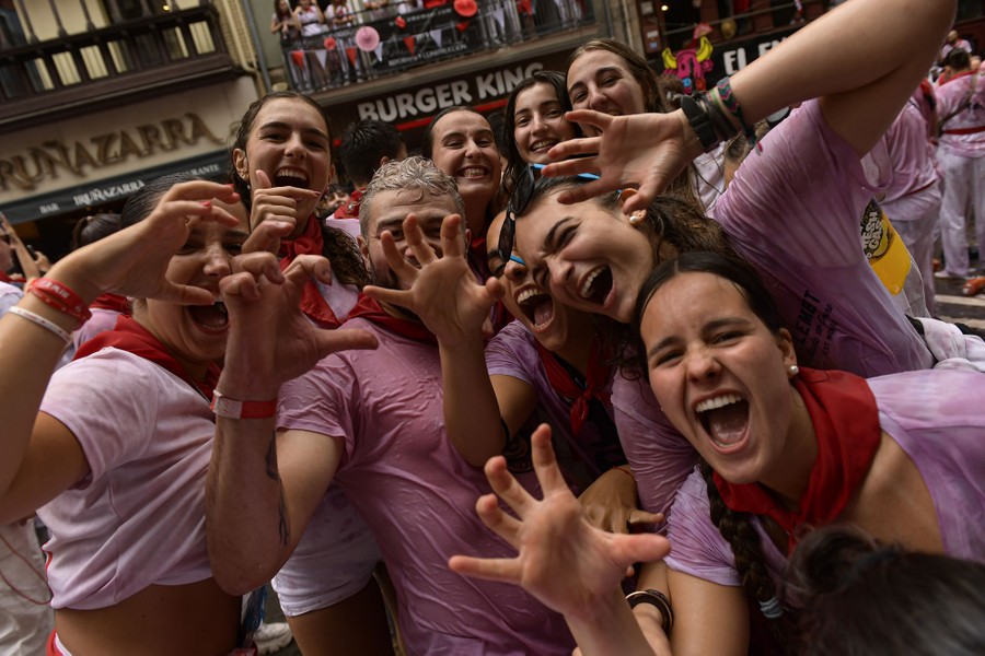 A group of festivalgoers poses for the camera, each person smiling and wearing a T-shirt soaked in water and wine.