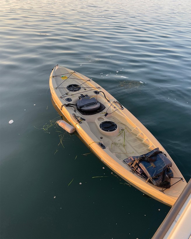 photo of open tan kayak floating on lake