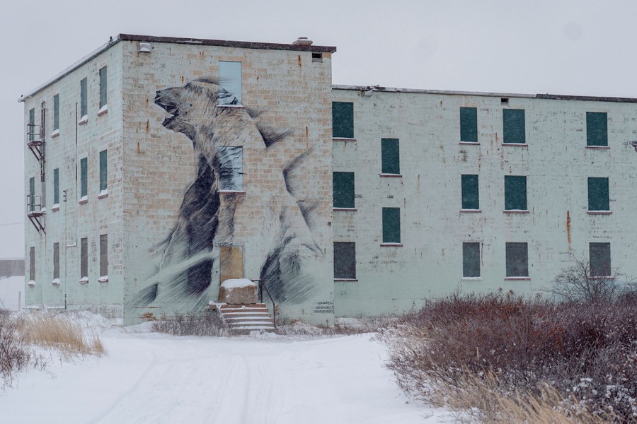 A three-story building has a mural of a polar bear painted on it.