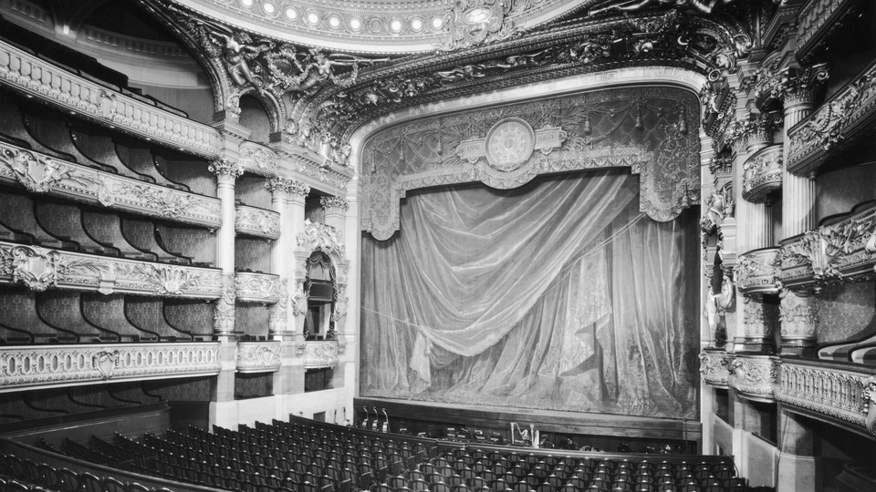 A black-and-white image of a grand old theater with many layers of balconies