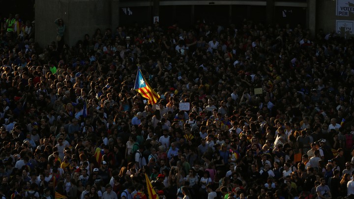A Catalan separatist flag flutters in the middle of a crowd.