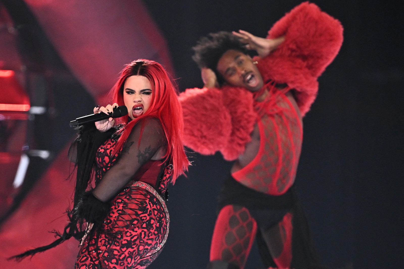 A singer and backup dancer perform on stage.