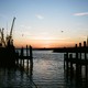 Sun sets over water at a fishing dock