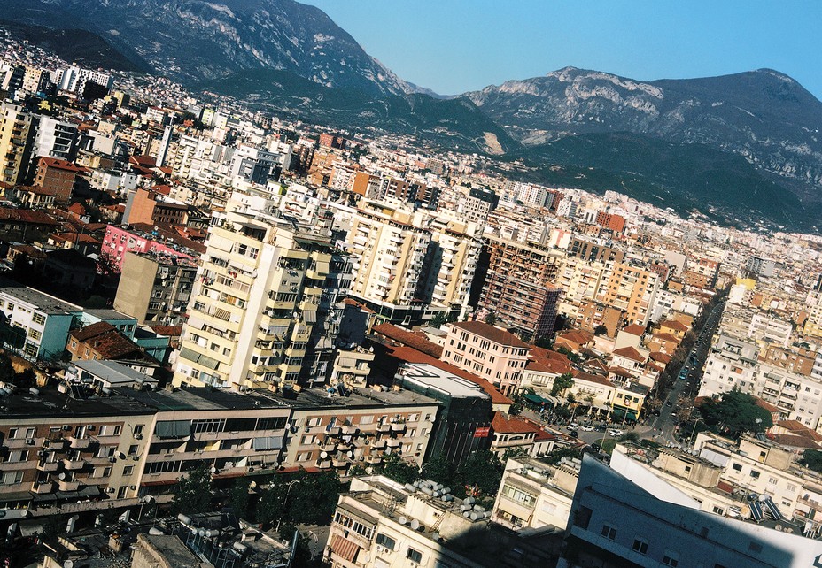 photo of the city of Tirana with blue sky and hills in background 