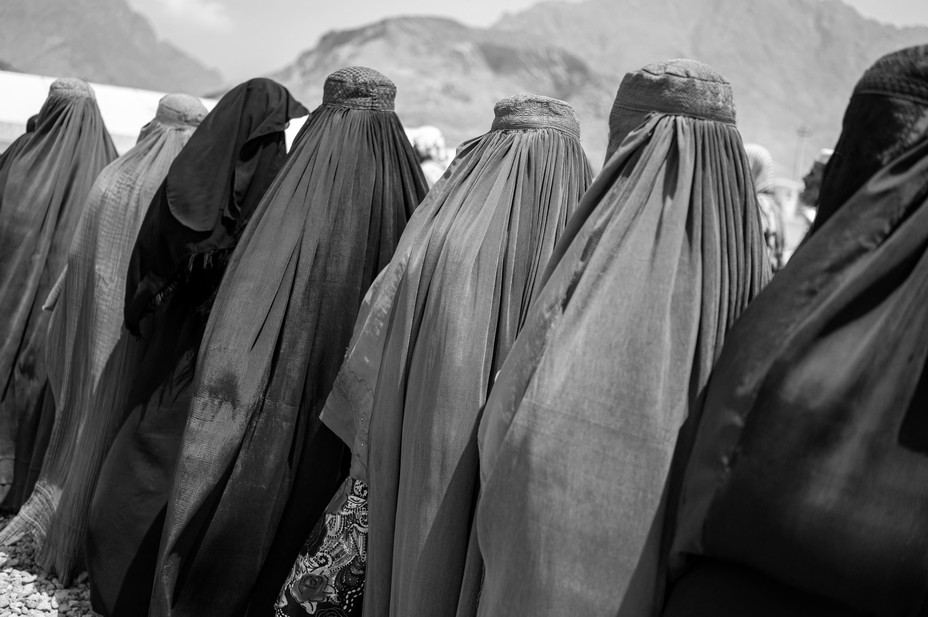 Picture of refugee women standing in a queue to identify themselves and get cash as they return home to the east of Afghanistan.