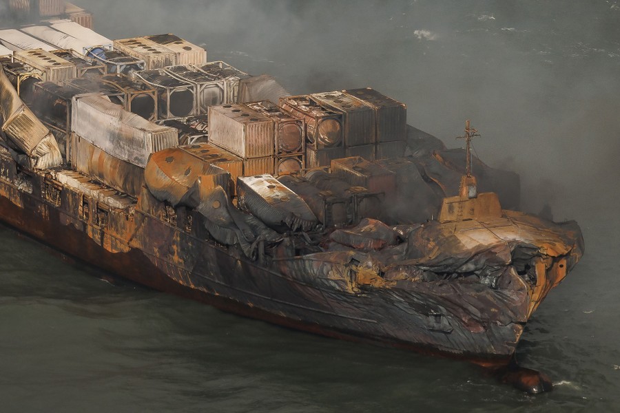 An aerial view of a burned and damaged cargo ship