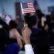A new citizen waves an American flag during a naturalization ceremony.