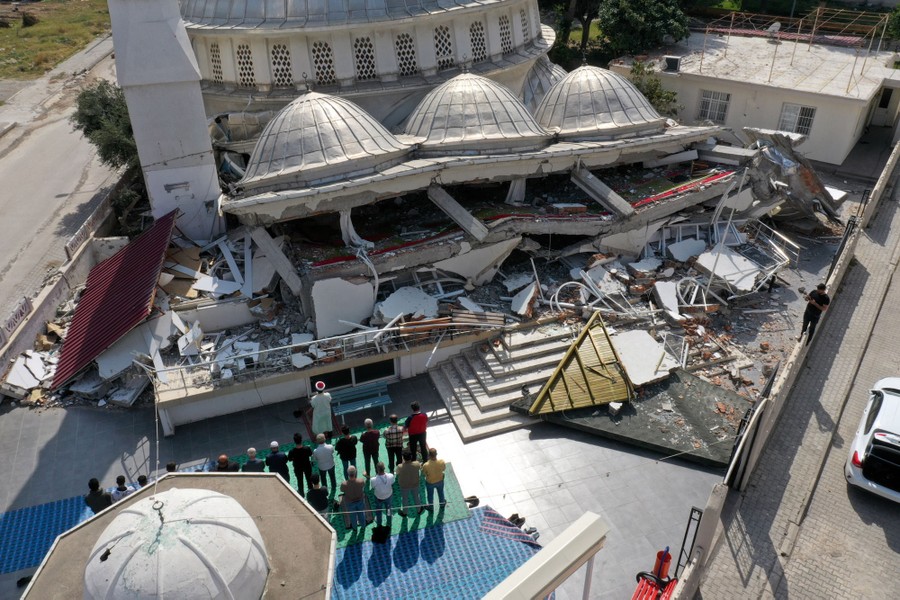 People pray in the courtyard of a destroyed mosque.