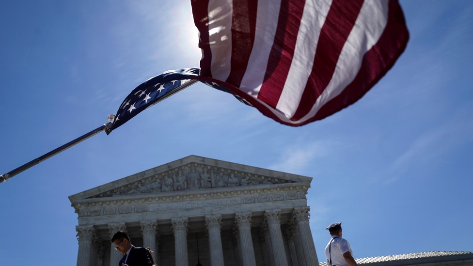 An American flag waving in front of the Supreme Court