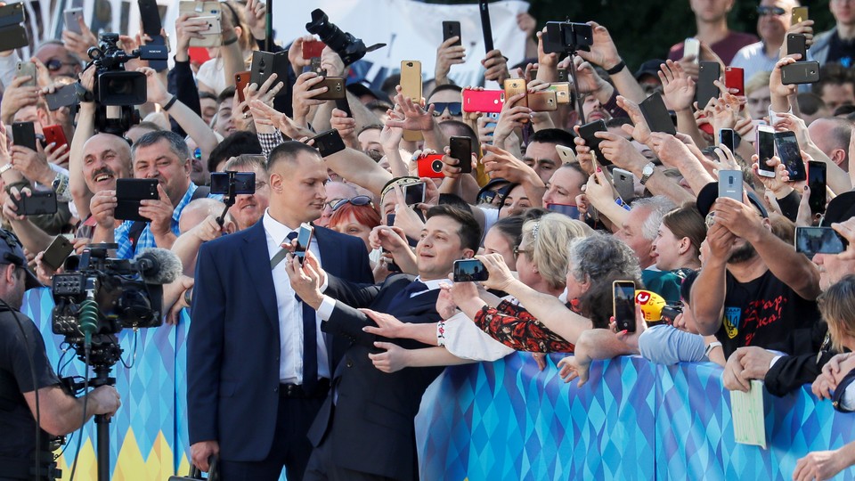 Ukrainian President Volodymyr Zelensky poses for selfies with voters.