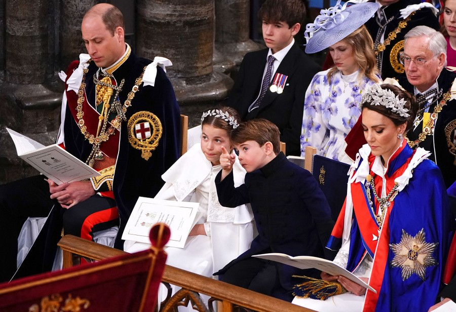 Royal family members sit together in formal attire.