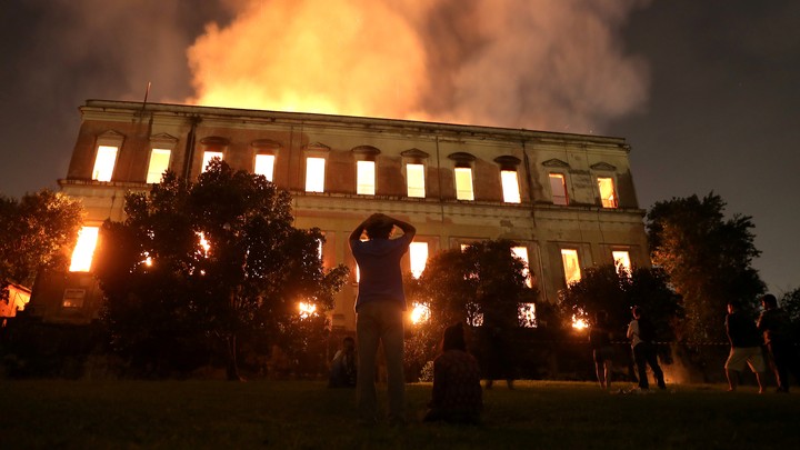 Outside spectators watch the National Museum in Rio de Janeiro burn.