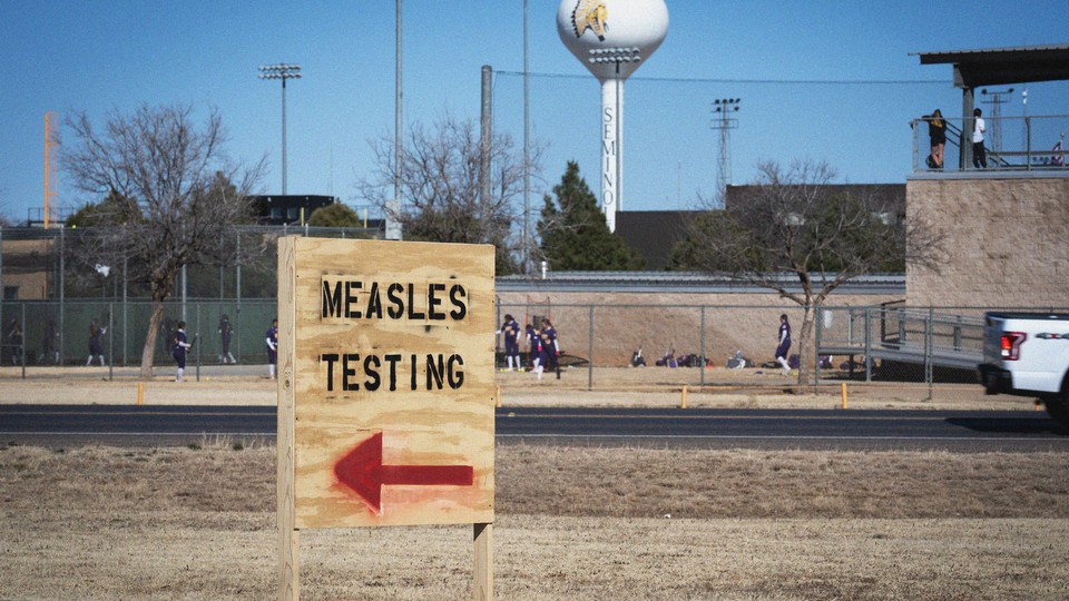 Signs point the way to measles testing in the parking lot of the Seminole Hospital District, across from Wigwam Stadium, on February 27, 2025, in Seminole, Texas.