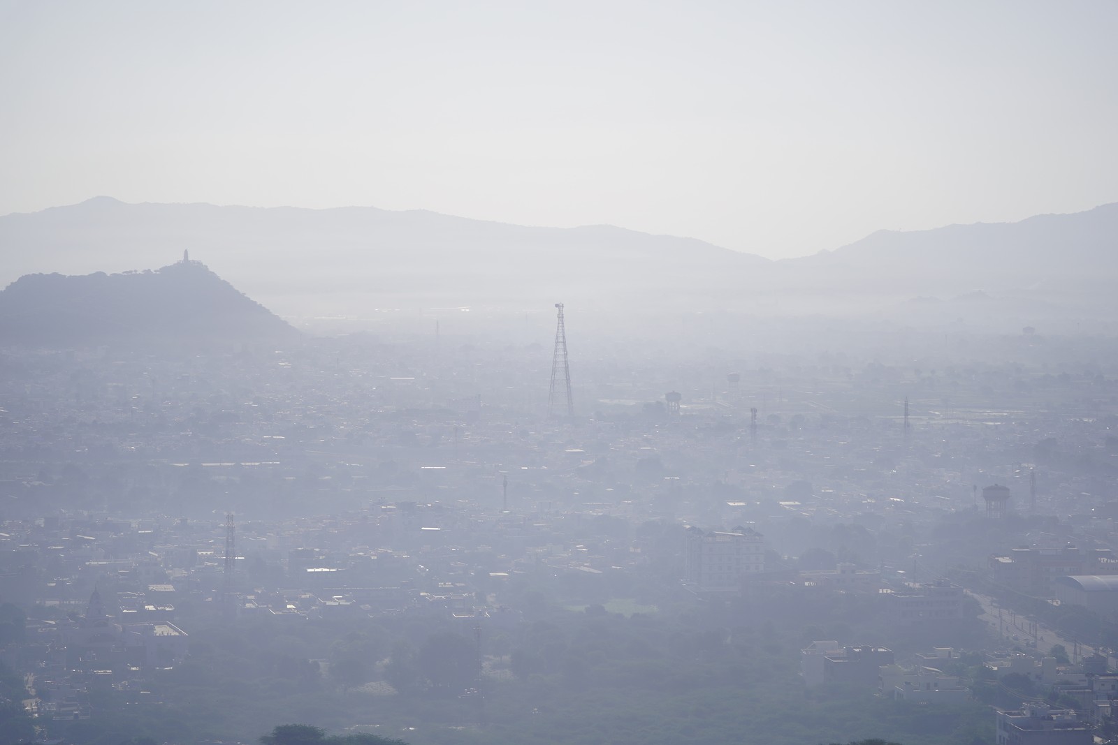 An elevated view of a city and surrounding Hills, all covered in a blanket of smog