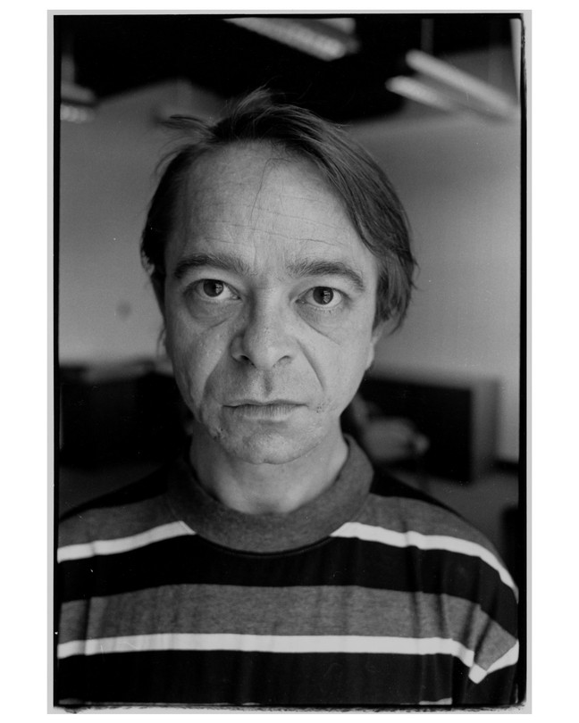 A black-and-white portrait of the writer Gary Indiana, seen head-on from the chest up.