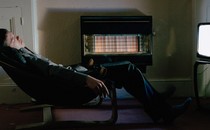 man sleeps in front of a TV