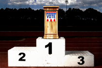 A dais with a "vote" sign sitting atop a winner's podium on a running track