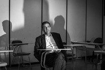 Black-and-white photo of Ro Khanna sitting at a desk in a classroom