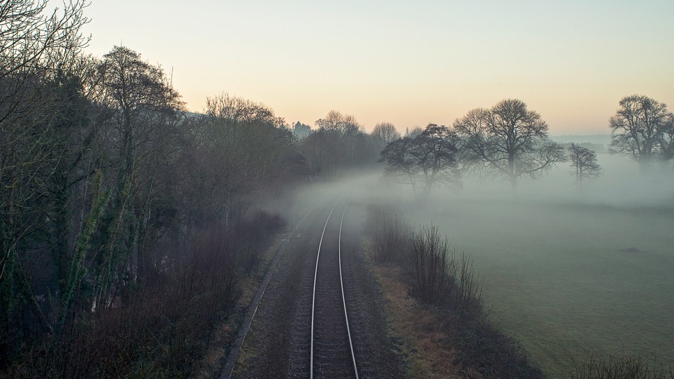 A photo of train tracks shrouded in fog