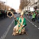 A performer dressed as as Saint Patrick poses with his staff as if it were a rock guitar, during a St. Patrick's Day parade.