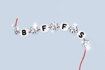 A red thread strung with beads that read "BFFS," interspersed with sparkling diamonds